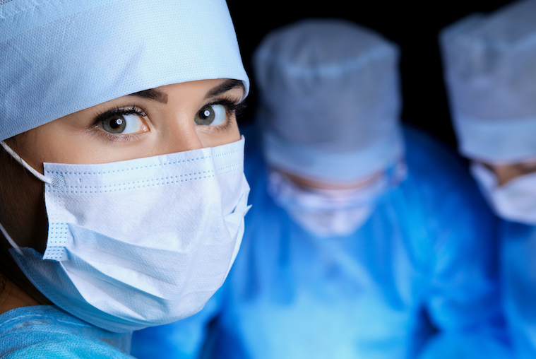 Three healthcare professionals mid-surgery, with the camera focusing on one