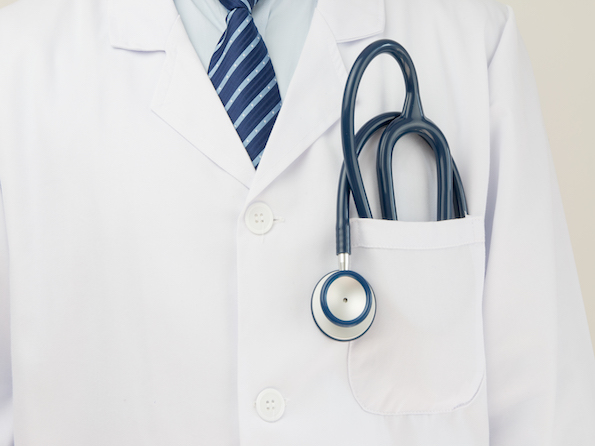 Close up photograph taken of a doctors white coat, tie, and stethoscope