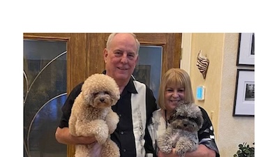 hombre y mujer sonriendo con dos perros