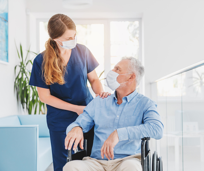 Younger nurse with an older patient sitting on a wheelchair