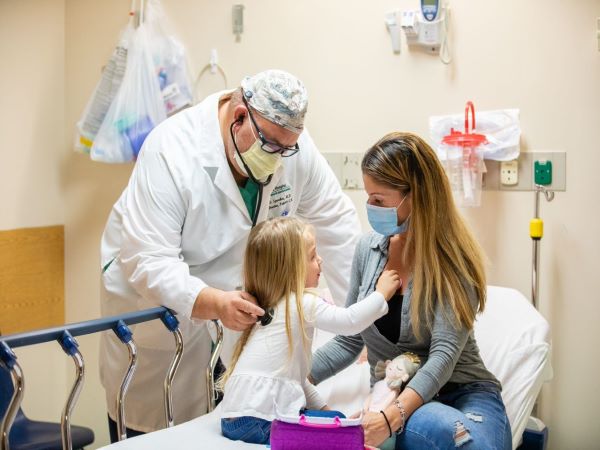 Doctor helping mother and child patient